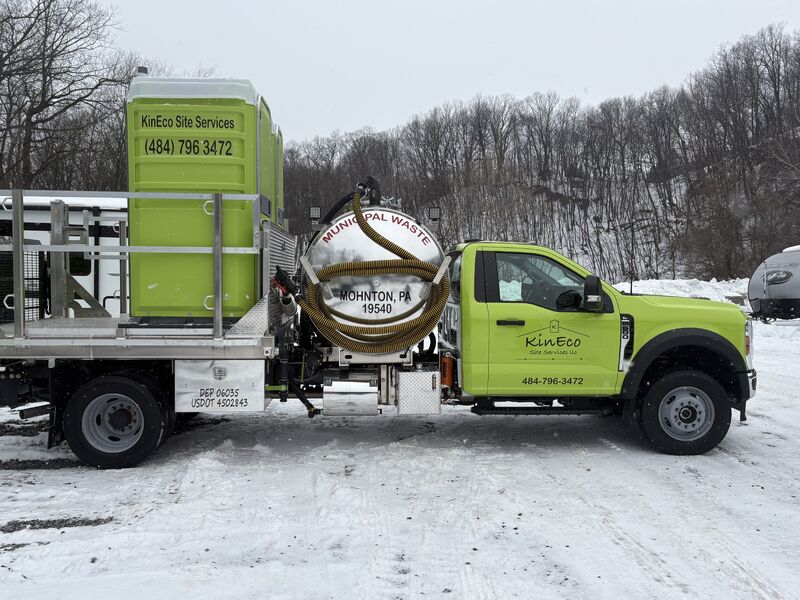 KinEco lime green service truck loaded with portable restroom